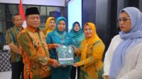 H Waris Tholib di Dampingi Ny. Hj Fatiah Haitami Waris Serehakan Baju Kader PKK Kecamatan se-Kota Tanjungbalai